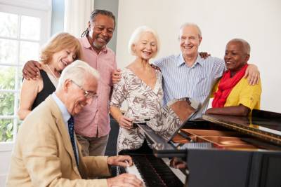 Groupe de seniors actifs autour d'un piano